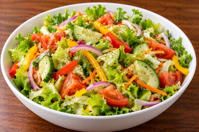 Fresh green salad with lettuce, tomato, cucumber, onion and capsicum