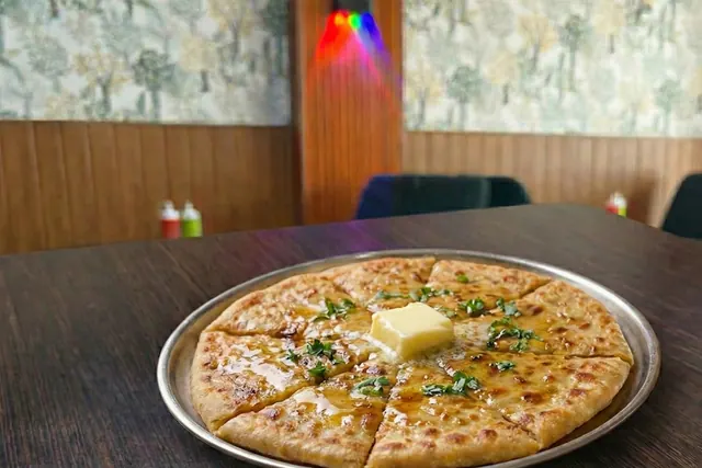 Stuffed aloo paratha cut into wedges with a pat of butter