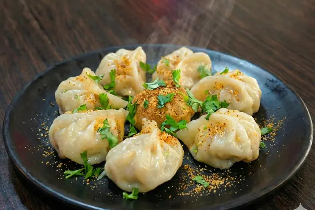 Steamed paneer momos with chutney and chilli sauce