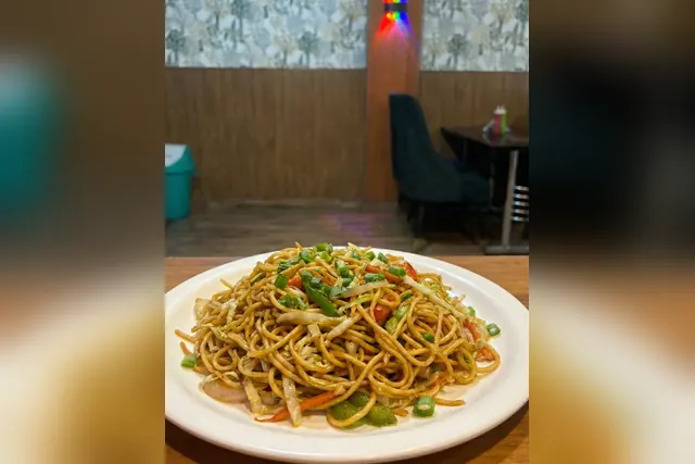 Stir-fried veg noodles on a white plate