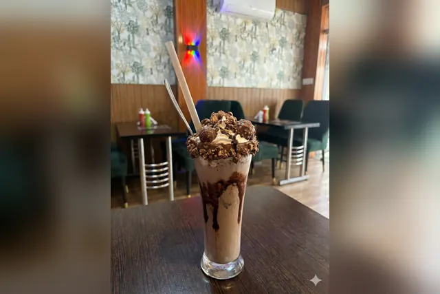 Thick chocolate shake with chocolate drizzle in a tall glass