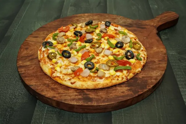 Veggie delight pizza with olives, corn, capsicum and jalapeno